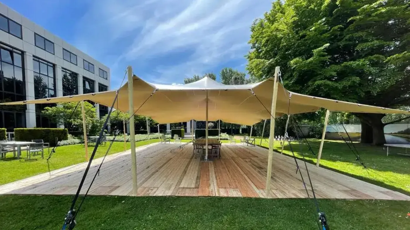 Gran estructura tensada de sombra para un evento al aire libre sobre césped