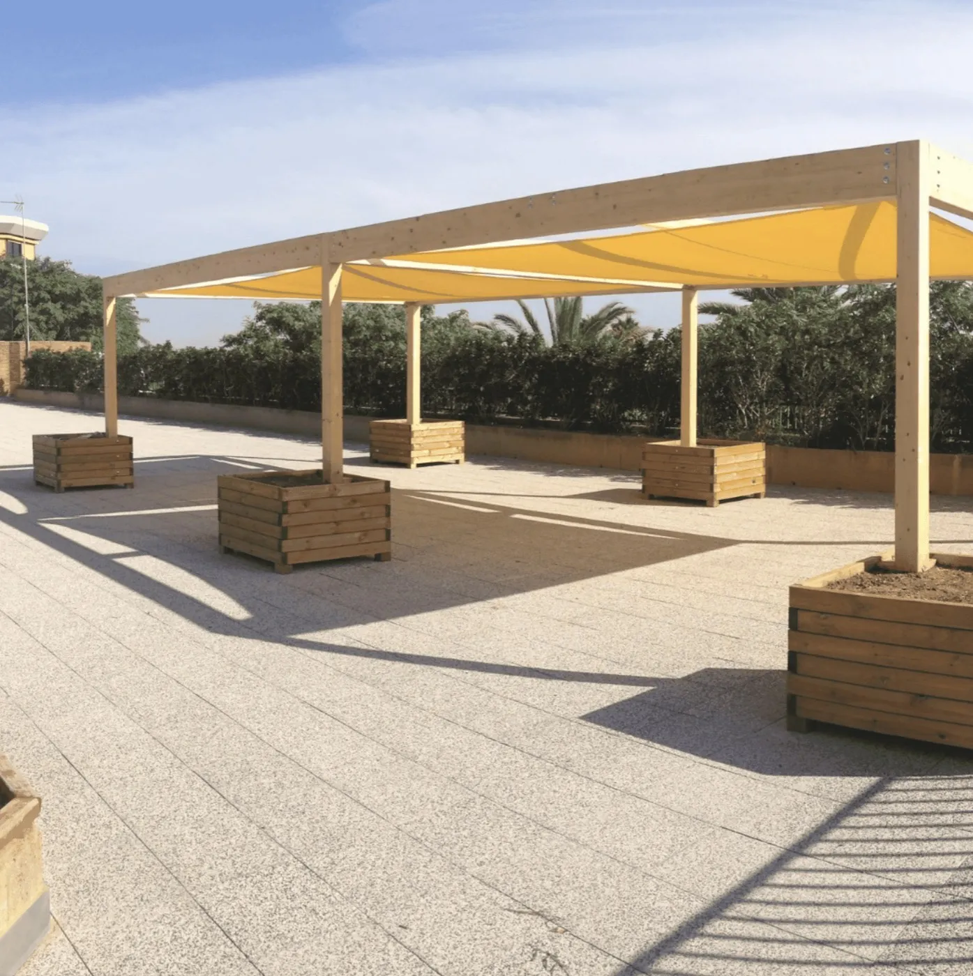 Rectangular shade sails over a public square with benches