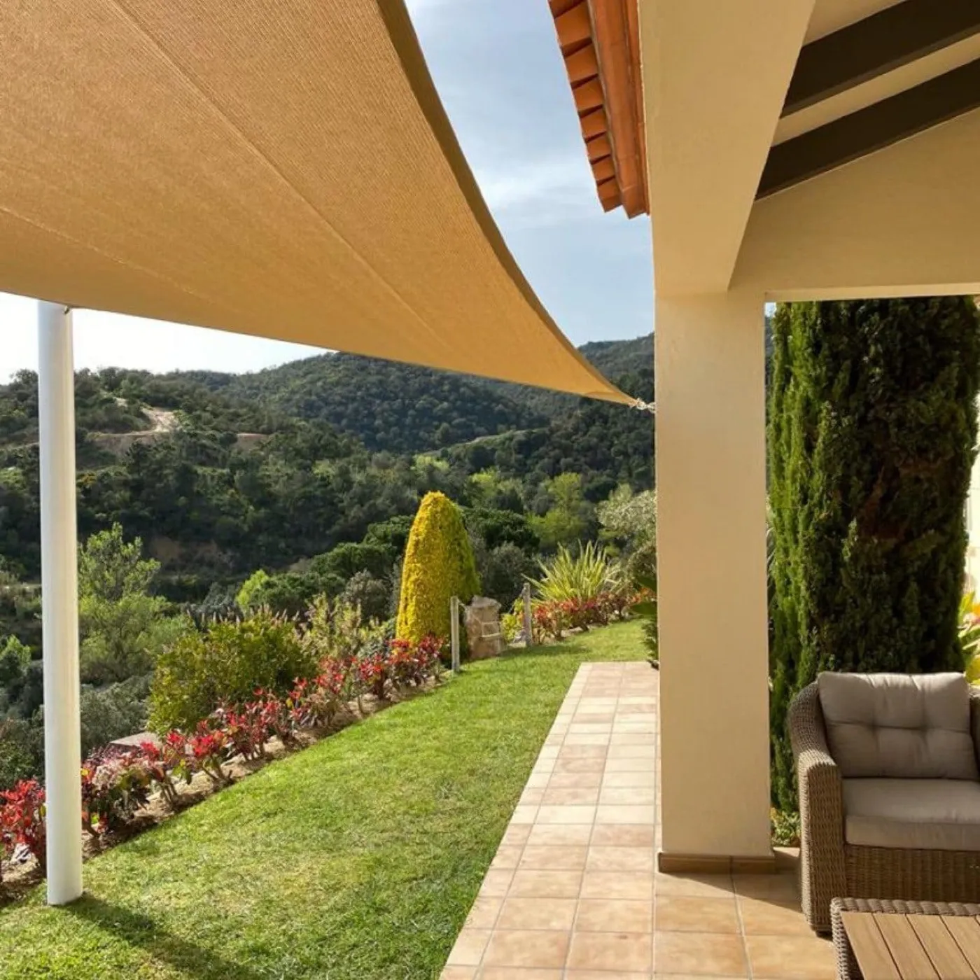Sand shade sail beside a garden path with mountain views